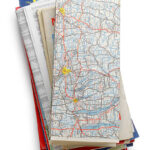 A stack of road maps isolated on white. Clipping path included.